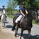 A procession of children on horseback in a rural setting
